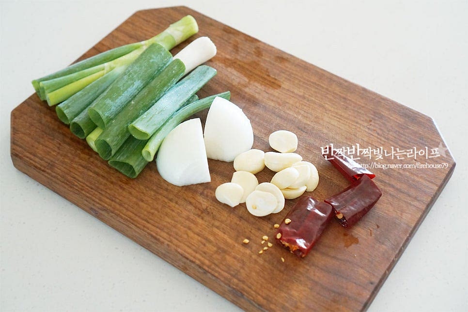 간장 연어장 소스를 만들어보아요. 각종 채소를 넣고 한소끔 끓여 식힌 뒤 숙성하여 줄 것이라 먼저 끓여줍니다. 대파와 양파는 큼직하게 썰고, 마늘은 크기에 따라 반으로 편 썰어요. 건고추는 가위로 꼭지를 잘라내고 3~4등분 하여 줍니다. 냄비에 양념재료를 넣어줍니다. 진간장 100ml, 맛술 70ml 쯔유 2 큰 술, 황설탕 1½ 큰 술 물 250ml 넣어줍니다. 간장과 함께 쯔유를 넣어 감칠맛을 더해주었어요. 쯔유는 농축 정도에 따라 양을 가감해 주세요. 대파, 양파, 마늘, 생강 통후추, 다시마, 건고추를 넣어줍니다. 센 불로 끓이다가 팔팔 끓어오르면 약불로 낮추어 15분 뭉근히 끓여주어요. 오래 끓이면 쓴맛이 나는 다시마는 5분 끓인 뒤 먼저 건져내어 주어요. 불을 끈 뒤 3분 정도 뜸을 들여주어요. **간은 짭조름, 달콤, 매콤함을 입맛에 맞게 가감해 주시면 됩니다. 건더기를 체에 밭쳐 걸러준 뒤 양념 소스는 식혀줍니다.