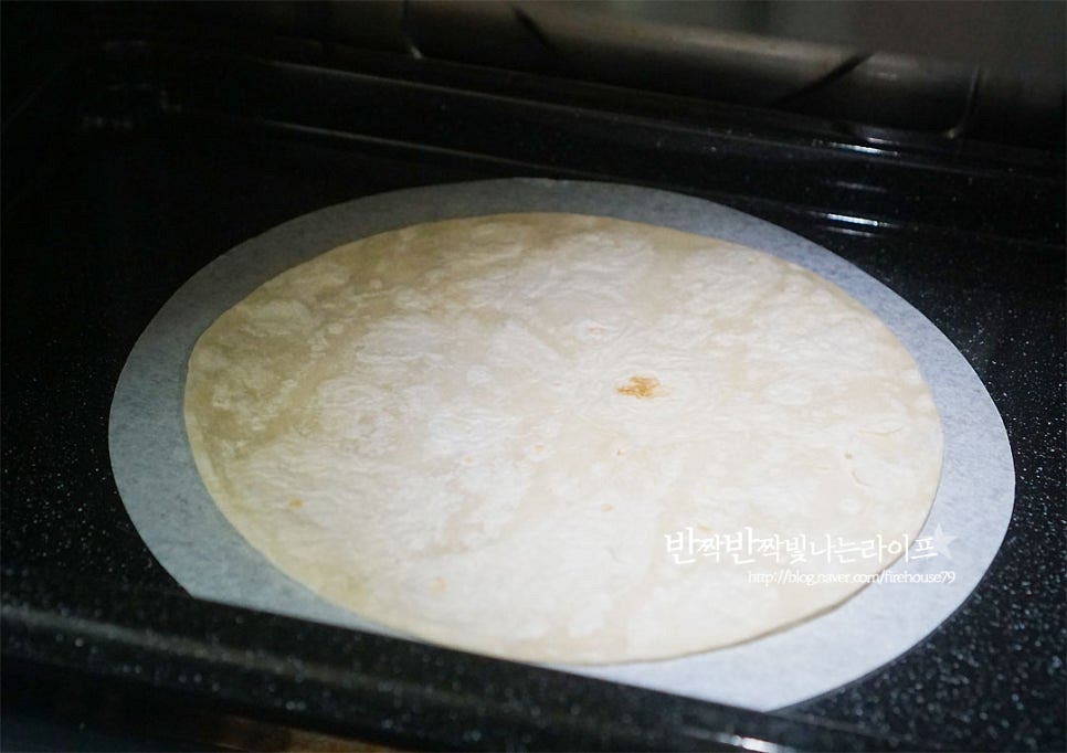 토르띠야는 전자레인지에 40초 정도 데워줍니다. 마른팬에 가볍게 구워주셔도 되고요~ 그 위에 먼저 치즈를 올려줍니다. 풍미 진한 체더와 모짜렐라가 섞인 걸 준비했는데 치즈가 들어가야 풍미가 더 좋아요~ 양상추도 넓게 펼쳐 올려주고요~ 로메인, 어린잎 등 다른 잎채소를 준비해 주셔도 됩니다. 재료를 취향껏 넣어 먹을 수 있는 게 바로 매력 포인트랍니다^^ 토마토와 파프리카도 넣어주어요. 바삭하게 튀겨낸 치킨을 올려주어요. 바삭바삭한 식감이 재료와 잘 어울려요. 매운맛 기호에 따라 할라피뇨를 올려주고, 허니 머스터드 소스도 같이 뿌려줍니다. 재료가 잘 어우러지도록 치즈를 조금 더 올려주었어요. 감싸듯이 말아서 모양을 잡아줍니다. 랩을 활용하여 김밥 말듯이 돌돌 말아주면 모양이 고정되어 손에 쥐고 먹기에 좋아요. 먹기 좋은 크기로 3등분 하여 썰어줍니다. 속 재료가 듬뿍 들어서 한 입 베어 물면 친근한 그 맛이에요. 바삭바삭 아삭아삭 식감과 함께 소스와 치즈가 어우러지는 풍미가 조화롭게 어우러진답니다~ 영상도 같이 담았어요. 치킨또띠아롤 특유의 매력이 있죠. 집에서 만들면 취향껏 재료를 푸짐하게 채워 넣어 만들 수 있어 더 맛이 좋은 것 같아요. 식빵이나 바게트와는 다른 매력의 얇은 빵 안에 들어서 더 속 재료의 맛을 풍성하게 맛볼 수 있답니다. 또띠아 샌드위치 맛있게 만들어 든든하고 푸짐하게 즐겨보세요. 맛있게 만들어 드세요^^ 끄읕 !