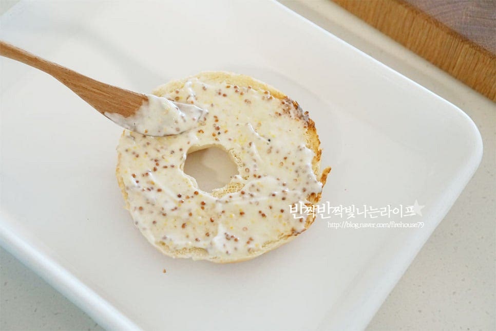 구운 베이글 위에 소스를 넓게 발라줍니다. 그 위로 레터스를 올리고 토마토와 계란프라이를 올려줍니다. 토마토는 크기에 따라 두세 개 겹쳐주세요. 햄과 치즈도 올려줍니다. 치즈는 두 가지 종류를 함께 넣어 고소한 맛을 더했어요. 치즈 종류는 입맛에 맞게 넣어주세요. 소스를 바른 베이글을 덮고 샌드위치 모양을 만들어줍니다.