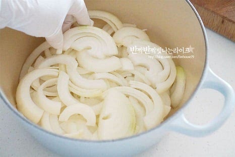 물을 넣지 않고 조리하기 때문에 바닥면이 두꺼운 냄비를 준비하는 게 좋습니다. 냄비에 양파를 먼저 깔아주고 사과 2/3 정도를 같이 넣습니다. 그 위로 된장을 바른 고기를 올려줍니다. 비계 부분이 위로 향하도록 올려주었습니다. 마늘과 생강, 대파, 통후추, 생강술(청주) 120ml를 부어줍니다. 마늘과 대파는 조금 넉넉하게 넣어도 좋습니다. 월계수잎 1장과 나머지 사과 1/3 분량도 올려서 재료를 모두 넣어주었습니다.