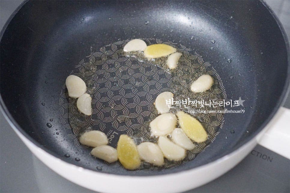 깊이가 있는 팬이나 웍을 준비한 뒤 예열 후 식용유 2 큰 술 두르고 마늘, 생강을 볶아 향을 내어줍니다. 향긋하게 마늘 기름이 만들어지면 삶은 연근을 넣고 함께 볶아줍니다. 전체적으로 골고루 식용유가 코팅되도록 2~3분 볶아줍니다. 볶은 뒤 조림 반찬을 만들면 잘 부서지지 않고 윤기가 납니다.