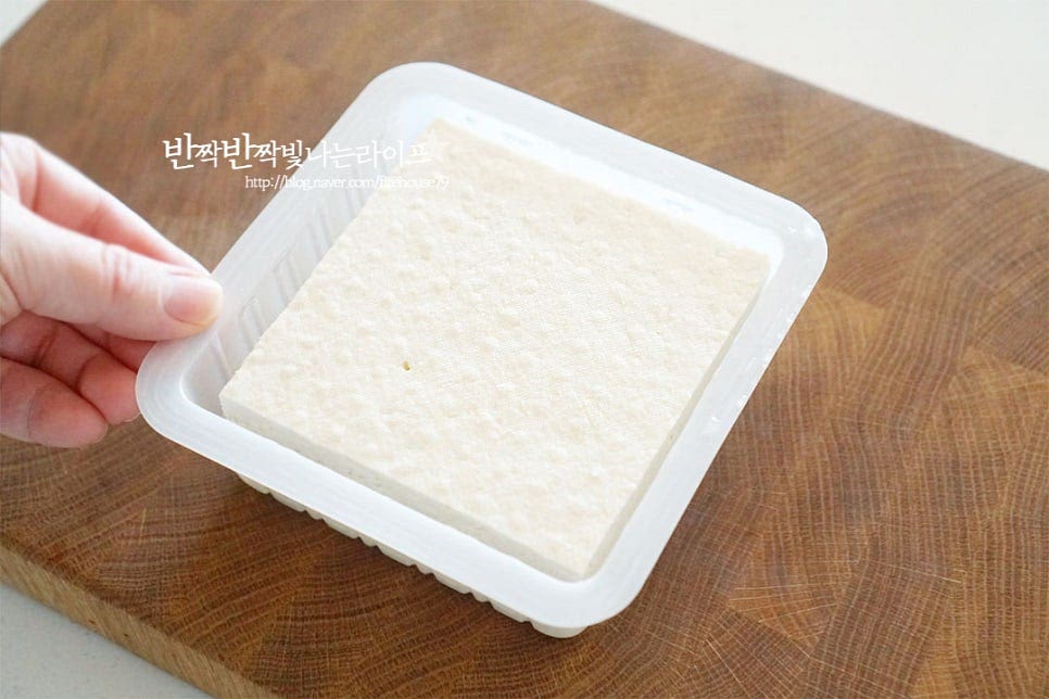 두부 한 모면 한 끼 든든한 반찬이 되는데요. 비교적 단단하게 두부구이를 만들 수 있는 부침용 준비했습니다. 집어먹기 좋은 크기로 잘라줍니다. 길이에 따라 반으로 길게 자른 뒤 대략 1cm 두께로 썰어줍니다. 적당히 두툼하게 잘라주면 구웠을 때 겉이 바삭하면서 속이 부들부들합니다. 두부구이의 식감을 살려 굽기 위해 수분을 제거해 줍니다. 키친타월 위에 하나씩 올려 물기를 빼줍니다. 물기를 제거한 뒤 구우면 바삭한 맛을 물론 뜨거운 기름에 올려 구웠을 때 튀어 오르지 않아요. 고소한 맛을 풍부하게 해주기 위해 소금 두세 꼬집을 골고루 뿌려줍니다. 소량의 간을 해주면 양념장 없이 그대로 먹어도 구수해요.