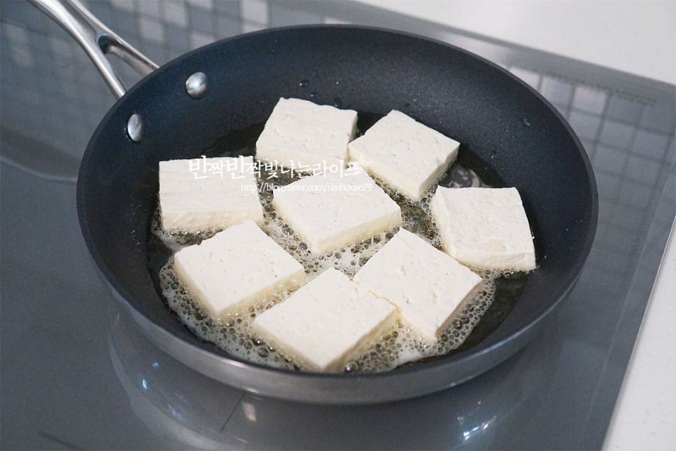 들기름에 구워 먹는 두부부침은 담백하면서도 고소한 맛이 좋은데요. 들기름만 넣으면 발연점이 낮아 식용유를 함께 넣고 구워줍니다. 들기름 2 큰 술, 식용유 1 큰 술을 두르고 하나씩 올려줍니다. 한쪽 면이 노릇하게 구워지면 반대로 뒤집어 익혀줍니다. 중불에서 겉을 바삭하게 구워주면 겉바속촉으로 맛볼 수 있어요. 노릇한 색감이 나도록 구워주면 식감도 좋고 고소한 풍미를 맛볼 수 있어요.