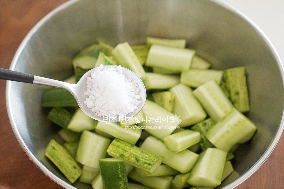 넉넉한 크기의 볼에 자른 오이를 넣고 천일염 1 큰 술, 물엿 2 큰 술을 넣어줍니다. 소금물에 절이거나 따뜻한 물에 절이기도 하는데 적은 양을 만들 때 간단하게 물엿을 넣으면 삼투압 작용으로 수분이 빠지면서 아삭한 식감이 더 맛이 좋습니다. 가볍게 버무린 뒤 30분 절여줍니다. 중간중간 골고루 절이도록 섞어주었습니다. 30분 정도 시간이 지나면 수분이 꽤 많이 생겨있어요. 체에 밭쳐 물기를 털어줍니다. 절여진 상태에 따라 짠맛이 강하다면 흐르는 물에 가볍게 헹구어주셔도 좋습니다.
