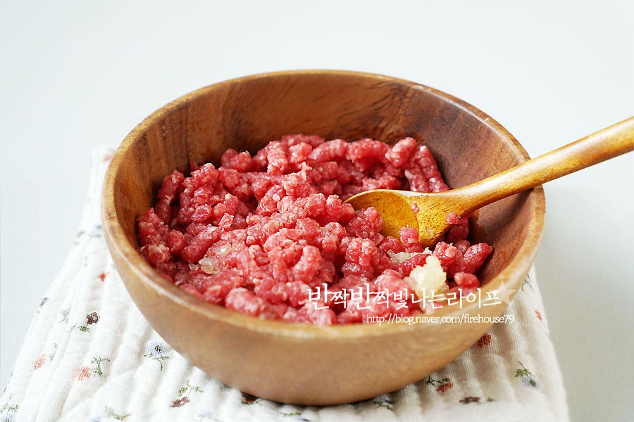 고명을 준비해 줍니다. 다진 쇠고기는 밑간을 해주는데 넉넉한 한줌 정도의 양에 맛간장 1 큰 술 맛술 1 큰 술 다진 마늘 조금 참기름 조금을 넣은 양념에 15분 정도 재워둡니다. 달걀지단을 만들기 위해 계란 두 개를 풀어 체에 밭쳐 한번 내려줍니다. 이 과정은 생략 가능한데 체에 내려주면 조금 더 부드럽게 만들 수 있어요. 달군 팬에 기름을 약간 두르고 달걀물을 얇게 펼쳐주고 구워줍니다. 얇게 굽다 보면 타기 쉬우므로 약불에서 익혀주다가 반 이상 익었을 때 뒤집어주세요. 지단을 올리는 것보다 푼 달걀을 좋아한다면 마지막 육수에 계란물을 풀어주어도 됩니다. 지단은 뜨거울 때 김밥처럼 돌돌 말아둡니다. 그럼 동그랗게 고정이 되어요. 한 김 식으면 얇게 썰어주세요. 그럼 동글동글 귀여운 지단이 만들어져요. 동그랗게 말지 않고 길게 채 썰어도 되고요. 밑간해둔 소고기도 팬에 볶아 준비해 주세요. 고명을 따로 준비해 주면 깔끔한 국물을 맛볼 수 있어요. 시원한 맛을 내어주는 대파도 쏭쏭 썰어줍니다.