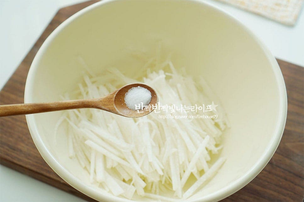 채 썬 무우는 소금으로 밑간해주는데요. 여기서 포인트는 소금을 아주 약간 감칠맛을 살릴 정도로만 뿌려주어요. 오히려 너무 많이 들어가면 절여지는 느낌으로 꼬들해져버려요; 가볍게 버무려 잠시 두면 간이 스며들고 촉촉하게 수분이 생겨요. 밑간한 뒤 튀김가루 4 큰 술 넣고 뭉치지 않게 버무려줍니다. 양에 따라 가루는 가감하여 줍니다. 수분이 많은 재료이기 때문에 반죽에 따로 물이 들어가지 않고 서로 붙을 정도로만 가볍게 버무려 전 반죽을 만들어 주면 된답니다^^ 류수영 무전은 가루가 적게 들어가서 더 건강하게 재료의 맛을 살릴 수 있어요.