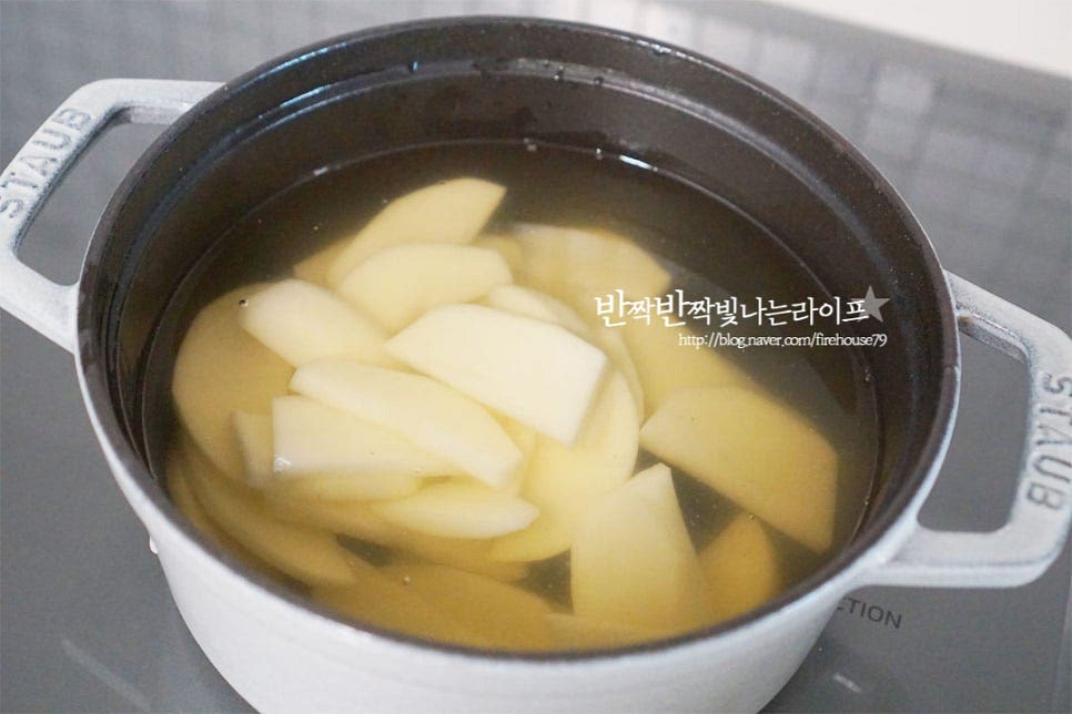 냄비에 우린 육수를 붓고 끓여줍니다. 끓어오르면 감자를 넣고 가볍게 저어주세요. 익는 데 시간이 걸리는 감자를 먼저 넣고 끓입니다. 다시 끓어오르면 중불로 낮추어 익혀주세요. 감자가 절반 정도 익으면 양념재료를 넣어줍니다. 참치액 1 큰 술, 국간장 1 작은 술 간 마늘 1 작은 술을 넣어줍니다. 대파도 함께 넣어주세요. 끓어오르면 간을 보고 부족한 간을 소금으로 맞추어주세요. 감자가 부서지지 않도록 두께에 따라 끓여가며 양념과 대파를 넣어주면 됩니다.
