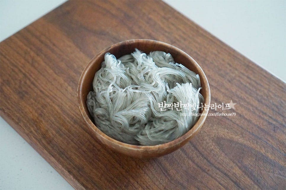 잡채 당면 삶기 건당면은 찬물에 30분 정도 담갔다 삶아주시면 되는데요. 저는 불리지 않아도 되는 것이라 찬물에 담그는 과정은 생략했어요. 냄비에 물 4~5컵 붓고 간장 2 큰 술, 흑설탕 1 큰 술 식용유 1 큰 술 넣어줍니다. 간을 하여 면을 삶아주면 밑간도 스며들고 색도 더 먹음직스러워진답니다. 3~5분 정도 삶아줍니다. 익은 정도를 확인하여 시간을 조절해요. 익으면 체에 밭쳐 물기를 털어 서로 붙지 않도록 참기름 1 큰 술에 버무려 줍니다.