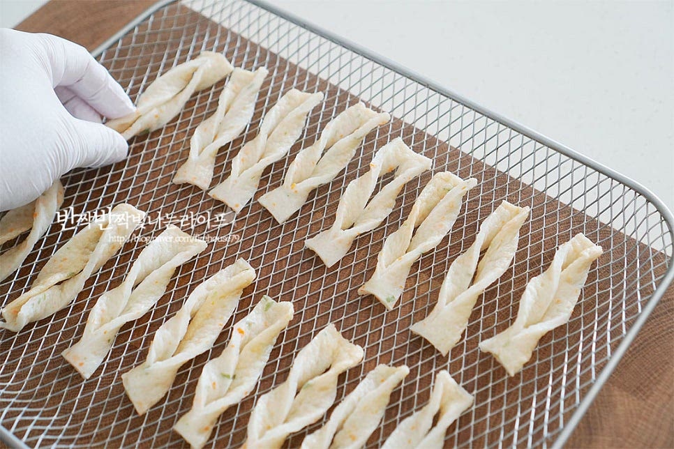 에프 트레이에 올린 뒤 겹치지 않게 펼쳐서 올려줍니다. 기름에 한번 튀겨진 재료이기 때문에 따로 식용유를 두르지 않아도 되며 종이호일을 깔지 않고 올려주어야 앞뒤로 바삭한 식감을 살릴 수 있습니다. 어묵튀김 에어프라이어 트레이를 에프에 세팅해 줍니다. 프라이팬에 기름을 둘러 튀겨주거나 전자레인지로 만들기도 하지만 에프로 요리하면 담백하면서 고소합니다. 어묵 에어프라이어 요리는 180도 8~10분 구워주면 됩니다. 기기의 사양에 따라 온도와 시간은 조절이 필요하며 중간에 구움색을 보아가며 조리해주세요. 재료에 묻어나는 기름이 데워지면서 겉이 바삭하게 익어간답니다. 따로 식용유를 두르지않아 간편하고 고소한 감칠맛을 느낄 수 있어요. 노릇하게 먹고 싶어 10분 정도 구워주었더니 색도 곱고 바삭바삭해요. 그대로 먹어보면 짭조름한 감칠맛이 풍부한데요. 튀겨서 만들어 뜨거울 때 바로 먹어야 식감과 맛이 더 맛깔나요. 간단하게 케첩과 마요네즈를 곁들여주었는데 청양마요소스나 고추냉이, 칠리소스를 곁들여도 별미이며 집에서 간단한 술안주는 물론 간식이나 떡볶이 토핑으로도 잘 어울린답니다. 영상도 같이 담았어요. 바삭바삭한 식감과 쫄깃한 식감이 먹을수록 감칠맛이 느껴지는데요. 한번 꼬아서 모양을 내어주어 먹는맛이 더 좋아요. 먹기좋게 자른 뒤 에프 온도와 시간에 맞추어 굽는 초간단 요리로 한 개 두 개 먹다 보면 빈 접시만 남게 된답니다. 어묵 에어프라이어 어묵칩 만들기 간단한 레시피로 맛있게 요리해드세요^^ 끄읕 !