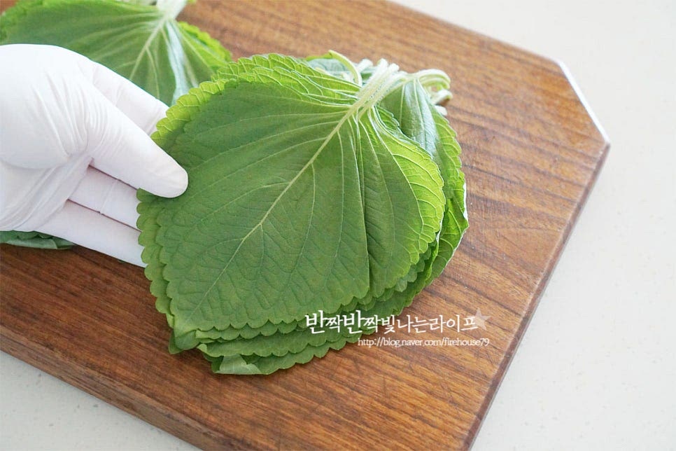 향긋한 깻잎은 쌈을 싸먹어도 맛있지만 특유의 향에 짭조름한 감칠맛 나는 양념장을 더해 깻잎반찬 만들면 밥 한 그릇 뚝딱하는 맛인데요. 간단하게 전자렌지로 요리하는 찜 레시피로 만들어보아요. 식초를 희석한 물에 담가 살살 흔들어 씻어준 뒤 흐르는 물에 헹구어 줍니다. 5~6장씩 겹쳐 탈탈 털어 물기를 제거한 뒤 체에 올려주면 자연스럽게 물기가 건조된답니다. 꼭지 부분은 집어먹기 좋도록 1~2cm 남겨두고 가위로 잘라 손질하여 줍니다.