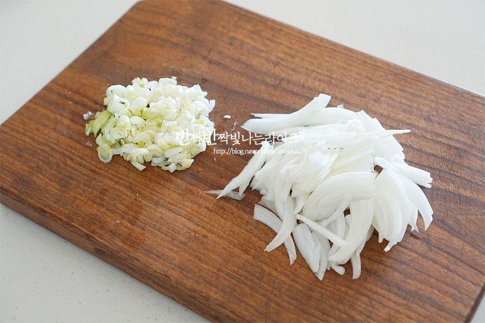 양념장에 들어가는 달큰한 향신 재료로 양파와 대파 흰 부분을 준비했어요. 그 외 당근을 채 썰어 넣어도 좋습니다. 대파는 반으로 갈라 잘게 송송 썰어주고, 양파는 반으로 잘라 얇게 채 썰어줍니다. 재료들과 어우러지도록 크기를 맞추어 잘라주었어요. 매콤 칼칼한 맛을 더해주는 고추는 잘게 썰어줍니다. 매운맛에 따라 양을 조절하여 넣어주는데 같이 넣어주면 매운맛이 재료와 잘 어울린답니다. 깔끔한 맛을 위해 씨가 많은 부분은 털어내어 주었어요.