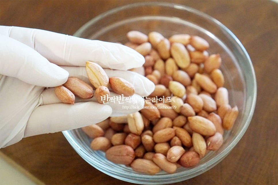 생땅콩을 준비했어요. 볶아서 간식으로 집어먹어도 맛있지만 단짠 간장 조림장에 졸여서 먹어도 밥반찬으로 맛있어요. 겉껍질은 벗긴 상태로 속껍질째 땅콩요리 만들면 고소함과 영양이 풍부합니다. 만들기 전에 불순물을 제거하고 떫고 쌉싸래한 맛을 잡기 위해 데친 뒤 요리해 줄 것입니다. 재료가 잠길 정도로 냄비에 물을 붓고 식용유 1 작은 술을 넣어줍니다. 식용유를 조금 넣고 삶으면 껍질이 벗겨지지 않도록 해줍니다. 센 불로 끓이다가 끓어오르면 중불로 낮추어 7~10분 정도 삶아줍니다 화력이나 양에 따라 삶는 시간은 조절해 주고 먹어보았을 때 아삭함이 느껴지는 정도면 됩니다. 10분 정도 삶다가 하나 먹어보니 아삭하면서도 부드러워요. 익힘 정도는 입맛에 맞게 조절해 주세요. 불순물이 꽤 나오기 때문에 흐르는 물에 헹구어 물기를 털어줍니다.