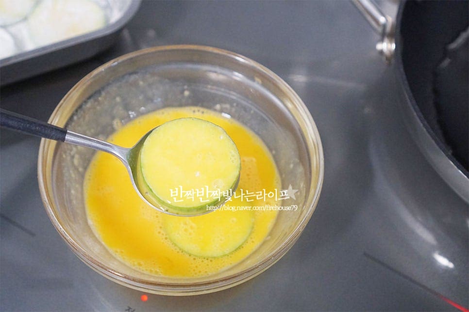 중강불 달군 팬에 식용유를 넉넉히 두르고 예열이 되면 숟가락을 활용하여 달걀옷을 입힌 호박을 덜어서 하나씩 올려줍니다. 겉이 타지 않도록 중간불 기준으로 조절해가며 구워줍니다. 홍고추 썰어둔 것도 하나씩 올려주었습니다. 앞뒤로 노릇하게 뒤집어 구워줍니다. 전을 구울 때 기름은 적당히 둘어주어야 색도 노릇하고 예쁘게 구워지고 고소한 풍미를 살릴 수 있습니다.