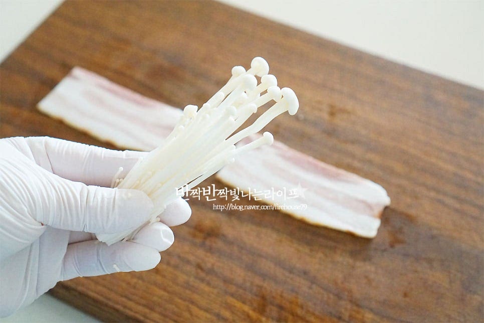 한입에 먹기 좋은 크기로 버섯을 나누어요. 익으면 생각보다 숨이 많이 죽기 때문에 약간 넉넉하게 넣어주셔도 좋아요. 베이컨 위에 올려줍니다. 끝부분에 올려 돌돌 말아줍니다. 김밥 말듯이 돌돌 말아 주시면 되어요. 익으면 부피가 줄어드니 모양을 꽉 잡아 말아주세요. 하나씩 돌돌 말아 준비해요.