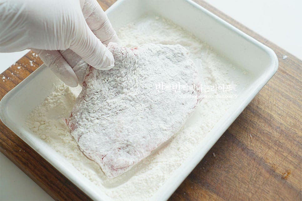 튀김옷을 입혀줍니다. 규카츠 우리가 잘 알고 있는 돈가스와 고기만 다를 뿐 튀김옷을 준비하는 과정은 같아요. 밀-계-빵 순으로 옷을 입혀줍니다. 먼저 밀가루를 꼼꼼하게 입혀 가볍게 털어내어 줍니다. 달걀을 풀어 계란 옷을 입혀주어요. 빵가루가 골고루 어우러지도록 해주는 역할이라 부드럽게 풀어 고르게 입혀줍니다. 마지막으로 빵가루를 입혀줍니다.
