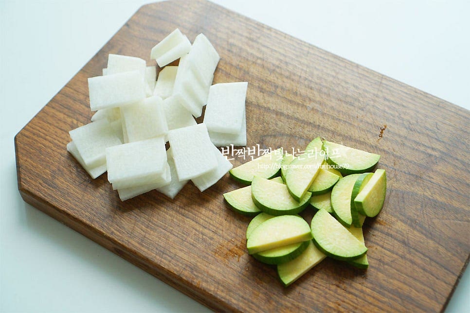 무는 나박 썰기하고, 애호박은 반달 모양으로 잘라줍니다. 양파는 채 썰고 대파와 고추는 어슷 썰어줍니다.