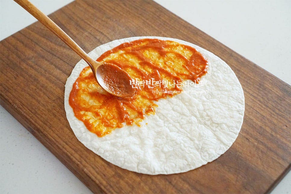 또띠아를 반으로 접어 구워줄 것이라 반지름 모양으로 토마토소스를 넓게 펴 발라줍니다. 소스 농도에 따라 양은 1~1½ 큰 술 정도로 조절하여 넣어주세요. 그 위로 치즈를 솔솔 뿌려줍니다. 불고기도 올려주고요. 볶은 야채와 버섯, 할라피뇨도 올려줍니다. 할라피뇨가 들어가면 정말 잘 어울리니 매콤하게 드시려면 꼭 넣어드세요. 아이용은 생략해 주시고요. 그 위로 다시 치즈를 뿌려줍니다. 재료가 넉넉하게 들어가면 맛있지만 너무 많이 넣으면 모양을 잡기 어려우니 밸런스를 맞추어 넣어주세요^^ 그리고 반으로 접어줍니다.