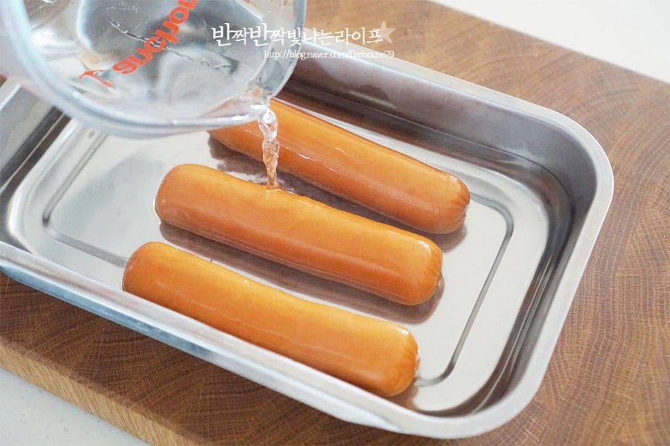 반죽을 만드는 대신 식빵으로 돌돌 말아 만들어줄 것이라 소시지도 길이를 맞추어 준비해 줍니다. 끓는 물에 가볍게 데치거나 뜨거운 물을 부어 가볍게 씻어줍니다. 바로 만들어도 되지만 뜨거운 물로 전처리해주면 첨가물을 제거하여 깔끔하게 요리할 수 있어요.