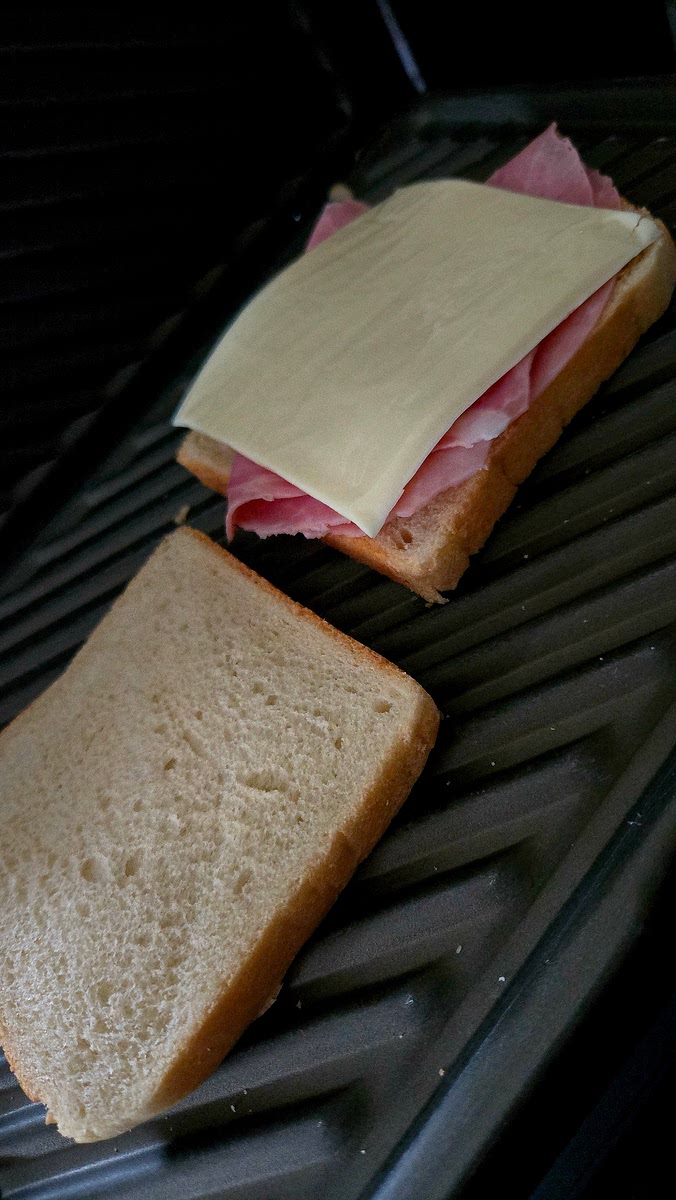 1 von 2 Toastscheiben mit Salami und Schinken belegen.