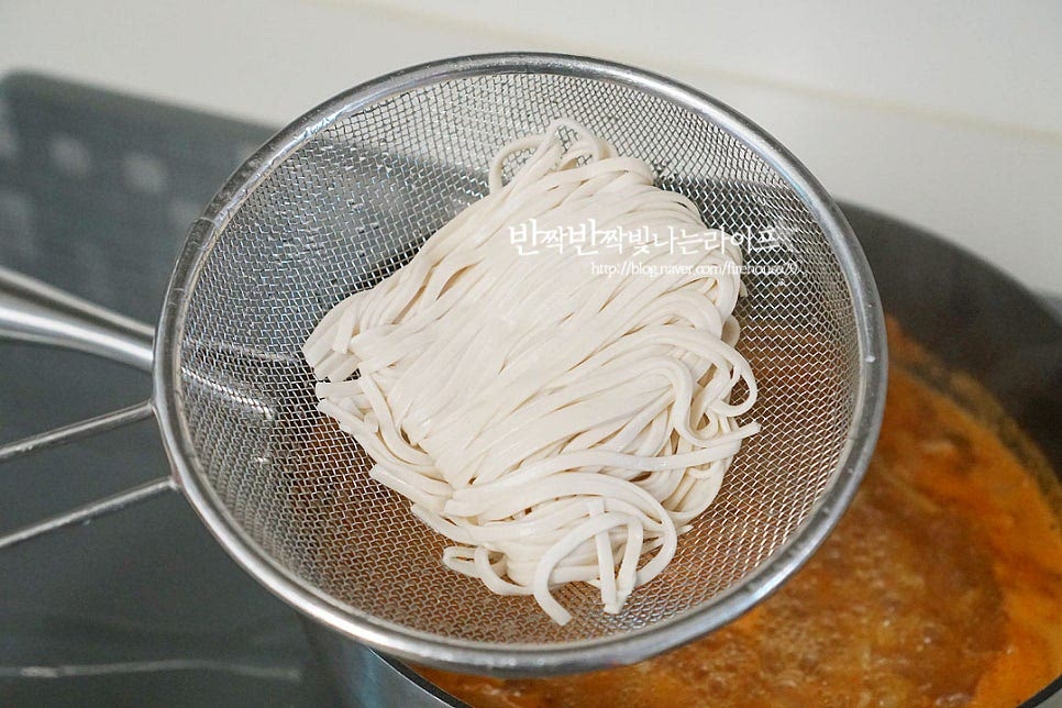 감자가 익으면 면을 넣어줍니다. 생면은 체에 밭쳐 흐르는 물로 겉에 묻은 밀가루를 가볍게 헹구어줍니다. 그대로 넣으면 걸쭉하고 텁텁해질 수 있어요. 억지로 면을 풀어 넣지 않고 모양 그대로 넣어줍니다. 자연스럽게 풀어지도록 해주어야 익으면서 칼국수 면이 끊어지지 않습니다. 바닥에 눌어붙지 않게 넣은 뒤 익으면서 풀어지면 젓가락으로 살살 저어주어 뭉치지 않고 익을 수 있게 해줍니다. 중불로 4분 정도 끓여 면을 끓인 뒤 다진 마늘 1/2 큰 술과 애호박, 고추를 넣어주어요. 마늘의 향이 풍미를 살려주고, 애호박은 오래 익히지 않아도 잔열로 익기 때문에 마지막에 넣어주었습니다. 칼국수를 맛있게 만드는법 마지막에 고소한 볶은 통깨를 갈아서 넣어주면 구수함에 고소함이 더해져 별미가 따로 없어요. 깨와 함께 김가루를 곁들여줍니다. 칼국수의 맛은 고추장과 함께 된장을 넣어 구수한 깊은 맛을 살리고 고춧가루와 청양고추로 매운맛을 더해주는데요. 여기에 장칼국수에는 감자가 들어가면 더욱 잘 어울리는 것 같아요. 영상도 같이 담았어요. 얼큰칼국수의 맛을 살리기 위해 양념재료를 볶아 깊은 맛을 더해 국물을 끓여주면 더 맛있게 맛볼 수 있답니다. 백종원 장칼국수 만드는법 얼큰하고 구수하게 요리해드세요^^ 끄읕 !