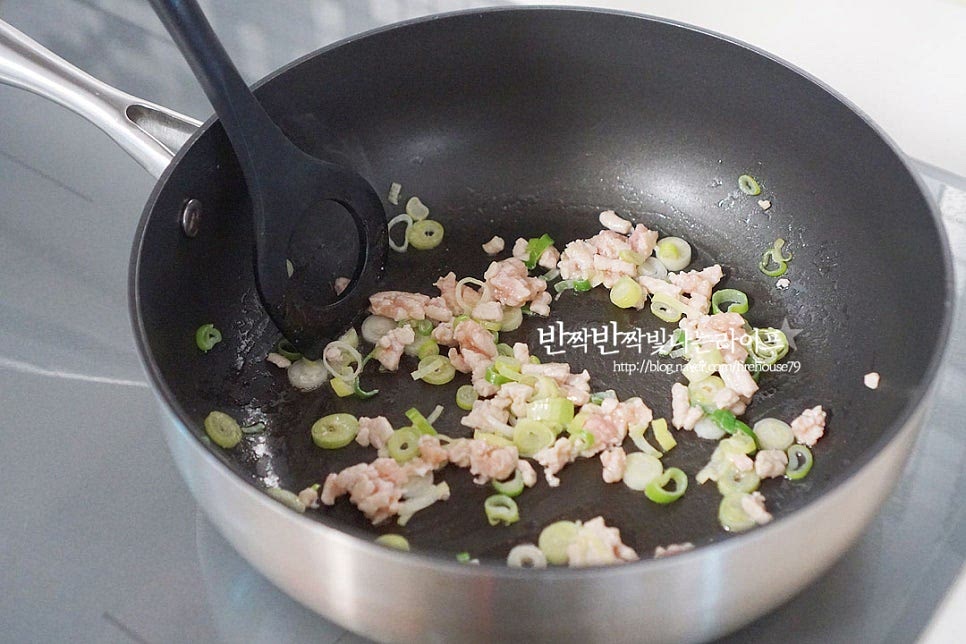 깊은 팬이나 냄비에 식용유 1 큰 술을 두른 뒤 다진 돼지고기와 대파를 넣고 볶아줍니다. 돼지고기 같은 경우 지방이 섞인 부위가 고소하게 맛이 좋아요. 뭉치지 않게 풀어가며 볶아줍니다. 대파가 나른하게 향이 올라오면 돼지고기가 익으면 된장 1/2 큰 술, 고추장 1 큰 술을 넣어줍니다. 집집마다 장맛이 다르기 때문에 짠맛에 따라 된장 양을 조절하여 줍니다. 서로 어우러지도록 뭉친 것을 풀어가며 볶아줍니다. 이렇게 볶은 뒤 칼국수 국물을 내어주면 조금 더 깊고 구수한 맛을 낼 수 있으며 텁텁하지 않고 깔끔합니다. 약불로 낮추거나 불을 잠시 꺼준 뒤 열이 따뜻한 상태에서 고춧가루 고운/굵은 것 각 1/2 큰 술 넣어줍니다. 고운입자가 없으면 굵은 것만 넣어도 좋아요. 온기가 있을 때 볶아주면 타지 않고 고추기름이 생긴답니다. 불을 켜면 탈 수 있어 낮추거나 꺼서 볶아주는 것이랍니다.