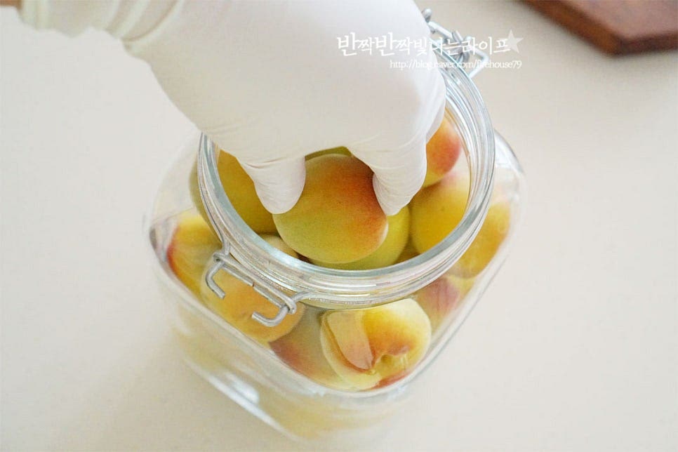 유리병에 과실을 담아줍니다. 숙성되는 과정에서 가스가 발생되기 때문에 70~80% 정도만 채워주시면 됩니다. 매실청 담그기 비율은 기본 과육 1 : 설탕 1입니다. 저는 홍쌍리 명인 레시피로 과육 1 : 설탕 0.5 : 올리고당 0.5 비율로 만들어 주었습니다. 먼저 올리고당을 넣어줍니다. 이때 과실 위로 묻어나도록 뿌려주어 곰팡이를 한 번 더 예방합니다. 그 위로 원당을 부어줍니다. 이때 과육이 보이지 않도록 설탕으로 덮어주어야 곰팡이 없이 맛있게 만들어져요. 3일 정도는 뚜껑을 덮지 않고 면포나 창호지를 덮어 가스가 날아가도록 해줍니다. 이렇게 덮어주셔도 좋고, 밀폐용기의 고무패킹 부분을 빼고 공기가 통하도록 덮어두셔도 좋아요.