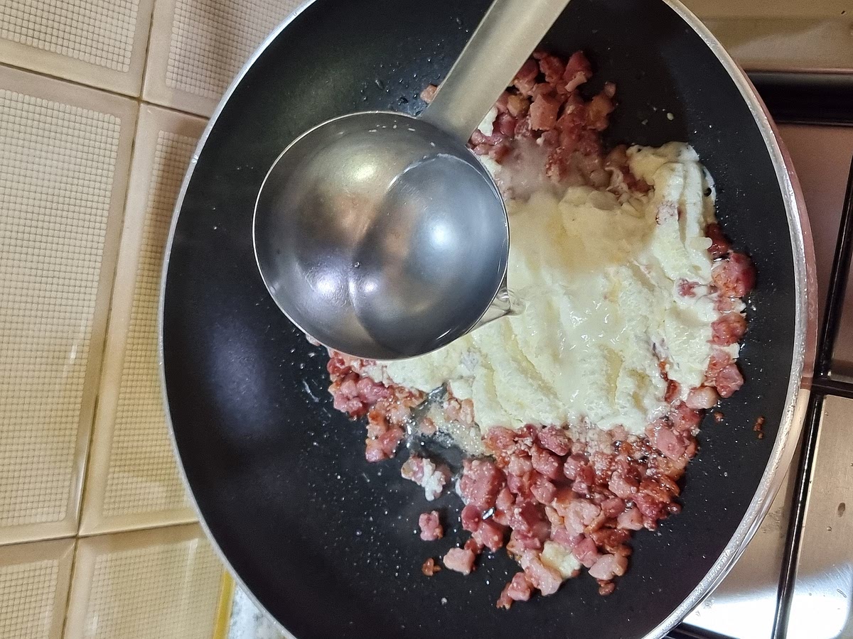 Aggiungere il pecorino e aggiustare di pepe a piacere. Versare un mestolo di acqua di cottura della pasta per mantenere cremoso il tutto e aiutare il pecorino a sciogliersi.