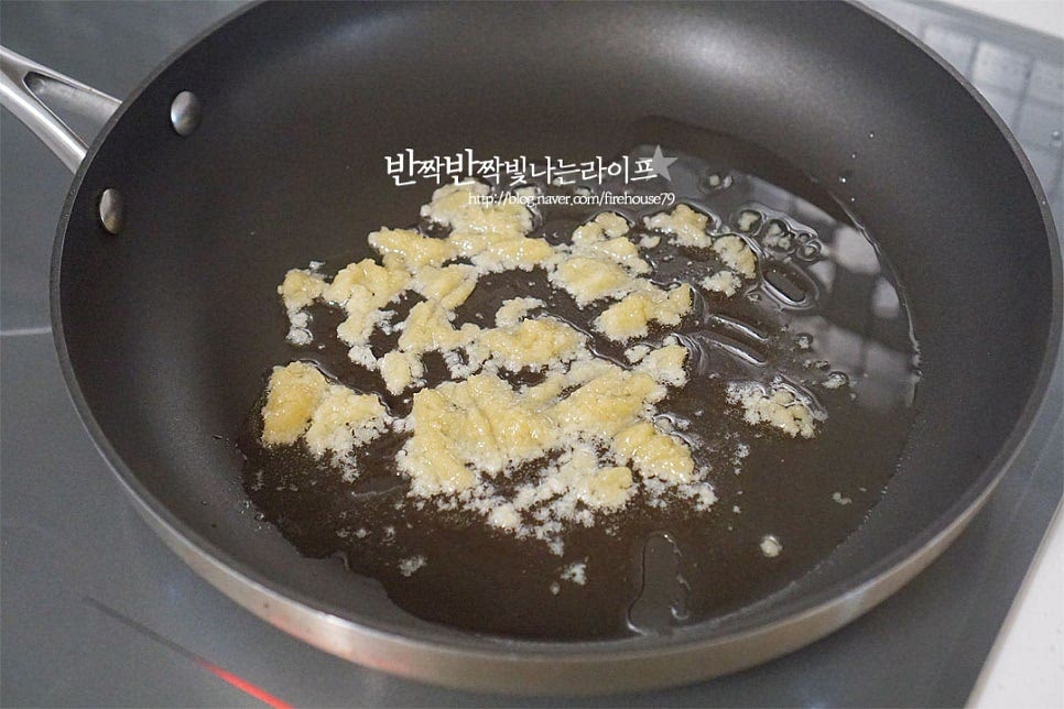 달군 팬에 식용유 3 큰 술, 간 마늘 1 큰 술을 넣고 마늘 향을 내어줍니다. 타지 않도록 중약불에서 볶아주세요. 촉촉하고 윤기나는 볶음을 만들기 위해 식용유는 적당히 넉넉하게 둘러주는 게 좋습니다. 마늘의 향이 올라오면 손질해둔 줄거리와 맛술 1 큰 술을 뿌려줍니다. 맛술의 알코올을 날리면서 전체적으로 골고루 버무려 볶아 마늘기름이 코팅될 수 있도록 해줍니다. 윤기나게 3분 정도 볶다가 양파와 당근, 고추를 넣어줍니다. 양파의 달큰한 맛이 잘 어울리니 가능한 같이 넣어주고 기본 채소 이외에 피망이나 파프리카를 넣어도 좋아요. 어우러지도록 볶아줍니다.