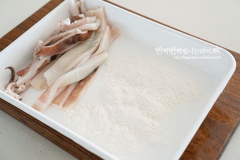 박력분(밀가루) 3 큰 술 정도 그릇에 넓게 펼친 뒤 오징어에 가볍게 묻혀 털어줍니다. 수분을 한 번 더 잡아주어 튀김옷이 벗겨지지 않게 하기 위해 1차 가루를 입혀주었어요. 너무 두텁지 않게 살살 흔들어 털어가며 얇게 입혀줍니다. 두껍게 입히면 반죽 옷이 두꺼워져요.