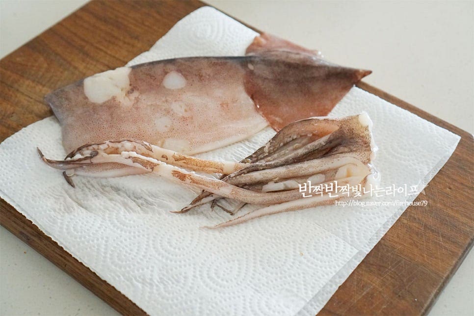 냉동실에 소분해두었던 오징어는 완전히 해동하여 준 뒤 흐는 물에 씻어줍니다. 그리고 물기를 제거해 줍니다. 수분이 많은 재료는 물기를 꼼꼼하게 제거해 주셔야 튀김옷이 분리되지 않으며 익히는 동안 튀지 않아요. 수분이 남이 있으면 기름이 튈 수 있어 조심하셔야 합니다. 몸통과 다리는 분리한 뒤 몸통은 1.5cm 너비로 일정하게 채를 썰어줍니다. 껍질을 벗기지 않고 그대로 요리해 주었는데 껍질을 벗겨 손질해 주셔도 좋아요. 다리도 모양 그대로 분리하여 썰어줍니다. 길게 썬 뒤 한 번 더 물기를 제거하여 주었어요.