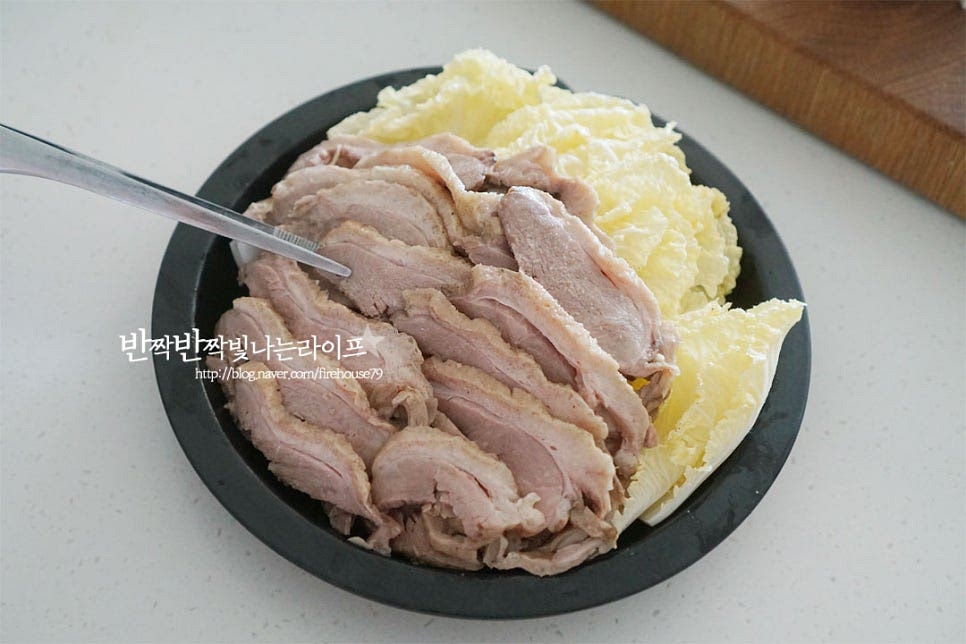 재료 준비가 끝나면 냄비 위에 찜기를 올려 촉촉하게 쪄주면 되는데요. 먼저 찜기 위에 배추를 올리고 훈제오리를 먹기 좋게 담아줍니다. 배추 위로 오리고기를 올리면 고기의 맛이 스며들어 더욱 맛있게 맛볼 수 있습니다. 야채 종류에 따라 익는 시간이 달라 먼저 훈제오리와 배추를 익혀줄 것이에요.