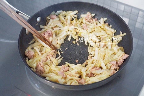 테두리로 볶은 양배추 참치를 밀고 가운데에 달걀을 깨뜨려 넣어줍니다. 약불에서 뚜껑을 덮고 익혀줍니다. 2~3분 정도 두었다가 뚜껑을 열면 계란이 먹음직스럽게 익어있어요. 익힘 정도는 입맛에 맞게 구워주세요.