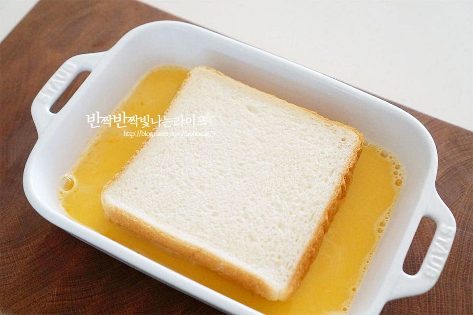 우유계란물에 준비한 식빵을 넣어줍니다. 속까지 촉촉하게 스며들 수 있도록 충분히 담가 재워주는데요. 뚜껑을 덮고 냉장고에 넣어 반나절 정도 재워둡니다. 앞뒤로 뒤집어 양면을 충분하게 적셔줍니다. 강민경 레시피는 전날 밤 만들어두고 다음날 조리해 주었는데요. 저도 늘 미리 만들어두고 구워 먹곤 하는데 속까지 보드랍고 촉촉합니다. 반나절 정도 냉장실에 넣어두었더니 계란 물이 흡수되었습니다.