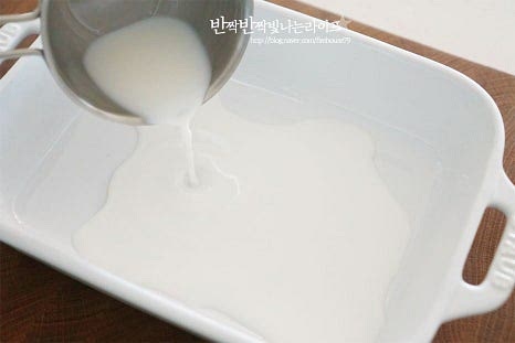 강민경 프렌치토스트 만들기 과정에서 중요한 것은 재료를 계량하여 만드는 것인데요. 넉넉한 크기의 넓은 볼에 식빵 무게의 우유 1/2, 설탕 1/4와 계란 2개, 소금 한 꼬집 넣어줍니다. 빵 무게를 기준으로 양을 조절해 주면 됩니다. 달걀의 비린내를 잡아주고 풍미를 끌어주는 바닐라익스트랙도 약간 넣어주는데요. 생략 가능해 주셔도 됩니다. 일반 식빵 두 개를 합치니 100g 정도 되어서 우유 50g, 설탕 25g 계란과 소금을 넣어주었습니다. 설탕 입자가 녹고 부드럽게 섞이도록 풀어줍니다. 숟가락으로 젓거나 거품기를 사용하여 뭉치지 않게 곱게 섞었어요.