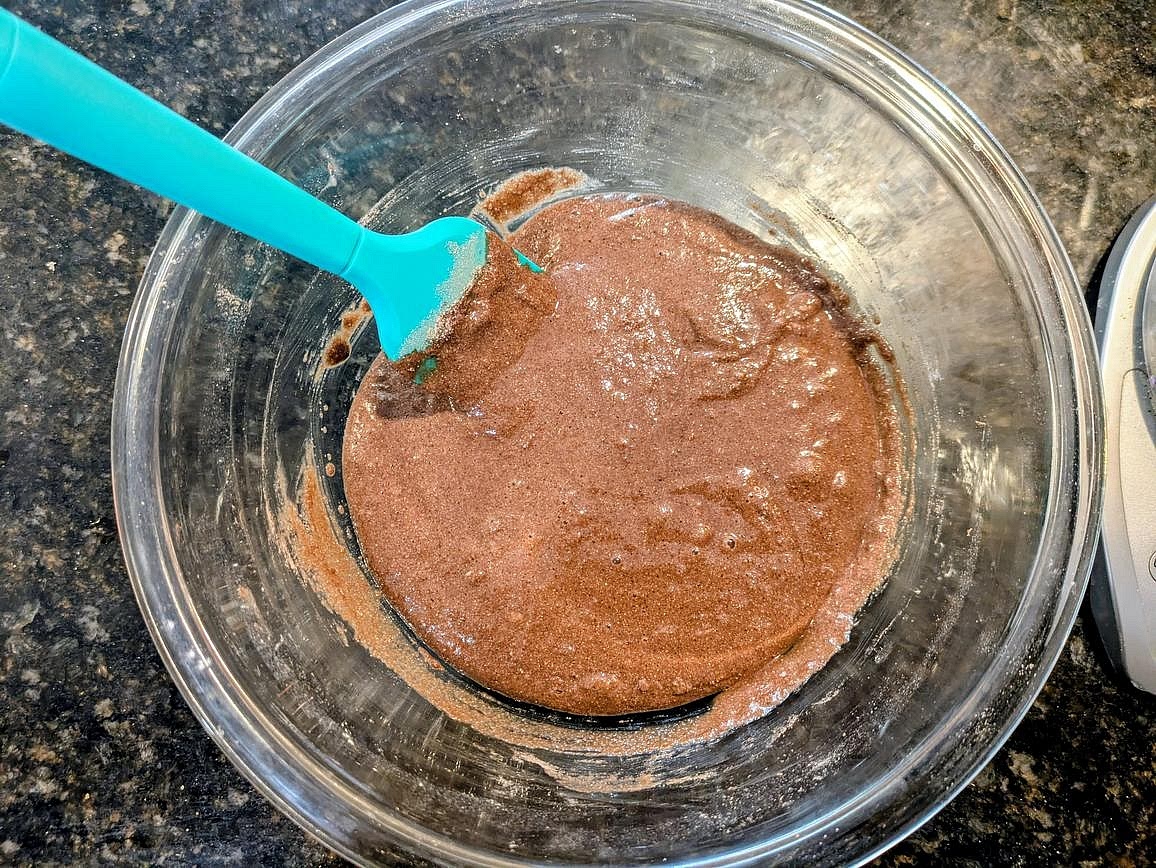 Add in the wet ingredients (vanilla, egg, almond butter, and water), and combine with a silicone spatula until combined and you have a thick but liquidy brownie batter