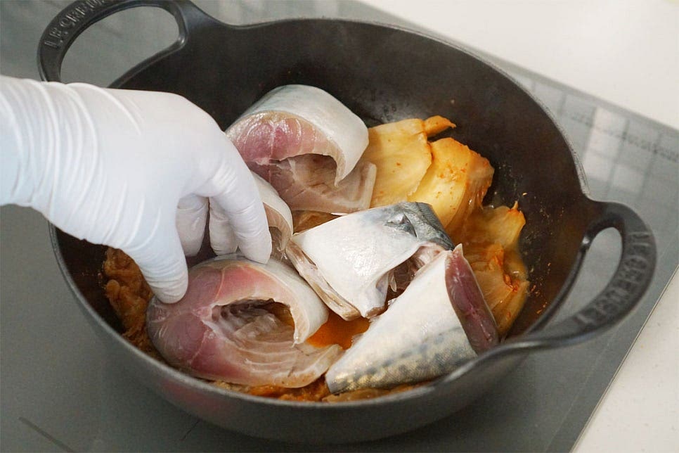 10분 뒤 고등어를 올려줍니다. 양파와 양념도 같이 넣어주어요. 양파는 달큰한 맛도 좋지만 생선 비린내를 잡아주는 역할도 해준답니다. 육수 200ml를 붓고 2차로 한소끔 끓여줍니다. 냄비나 화력에 따라 양을 조절하여 자작하게 넣어줍니다. 재료가 어우러지면서 생선이 익고 간이 밸 수 있도록 중간중간 양념소스를 끼얹어가며 익혀줍니다. 모두 익으면 대파와 고추를 넣고 마무리해요. 푹 익은 묵은지와 부드러운 고등어가 만나 얼큰한 감칠맛이 깊어졌어요. 생선살 발라서 묵은지 길게 찢어 밥 위에 올려서 먹음 밥 한 그릇은 뚝딱한답니다. 영상도 같이 담았어요. 매콤 칼칼한 맛이 어우러진 고등어 묵은지 김치찜은 추운 날 뜨끈하게 요리하면 별다른 반찬 없이 든든하고 푸짐하답니다. 비린내를 잡고 깊은 맛을 살리기 위해 들기름과 양념재료로 맛을 더해주면 더 맛깔나요. 고등어김치찜 양념 매콤하게 곁들여 맛있게 요리해 드세요^^ 끄읕 !