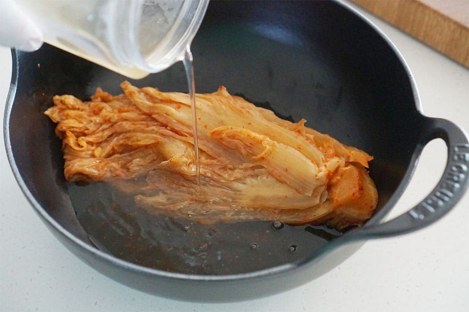 냄비에 김치, 멸치 다시마 육수 150ml 부어줍니다. 육수 대신 쌀뜨물도 좋아요. 잘 익은 묵은지로 짠맛과 신맛에 따라 양념을 더해주면 되는데요. 깔끔한 맛을 위해 안에 든 김칫소는 덜어내어 주었습니다. 재료의 잡내를 잡고 풍미를 살려주는 들기름 1 큰 술도 뿌려줍니다. 김치를 먼저 익혀준 뒤 고등어를 넣어 끓여줄 것이에요. 묵은지를 자르지 않고 포기째로 푹 익히면 쭉쭉 찢어먹는 맛이 있어 그대로 넣어줍니다. 구수한 맛을 내기 위해 1차로 끓여줍니다. 끓어오르면 중약 불로 낮추어 10분 푹 끓여 익혀줍니다.