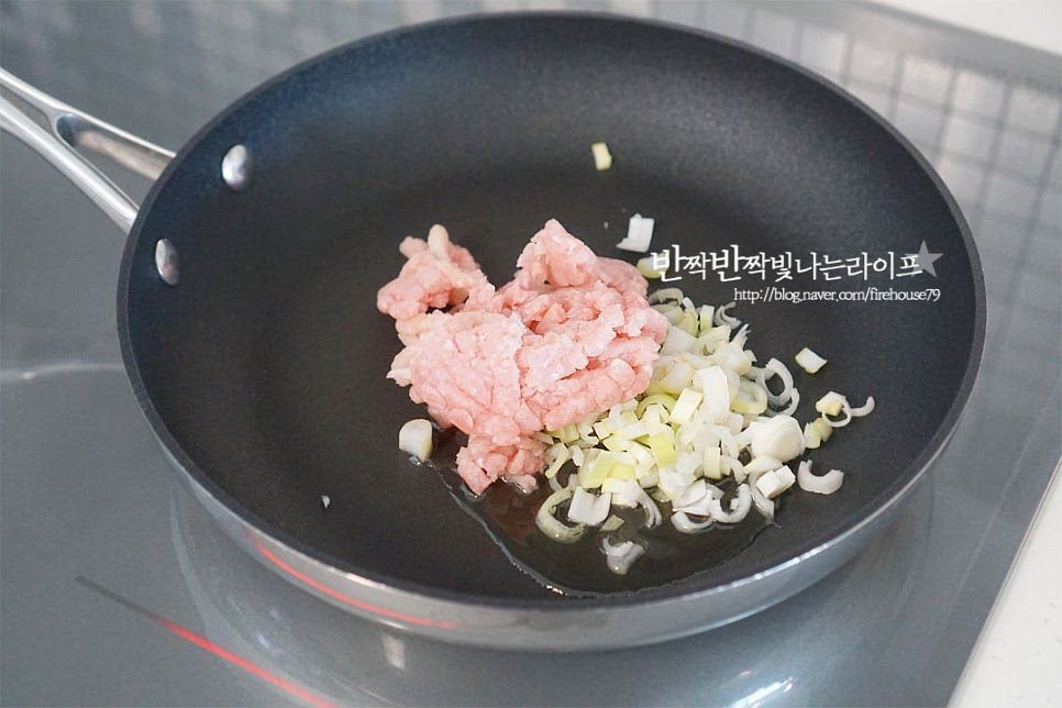 달군 팬에 식용유 2 큰 술을 두르고 다진 파와 돼지고기를 넣고 볶아줍니다. 돼지고기가 뭉치지 않도록 풀어가며 볶아줍니다. 돼지고기 기름이 나오고 대파가 노릇하게 익을 수 있게 눌어붙듯이 익혀줍니다. 고기의 단백질이 눌어붙어 풍미를 깊게 낼 수 있어요.