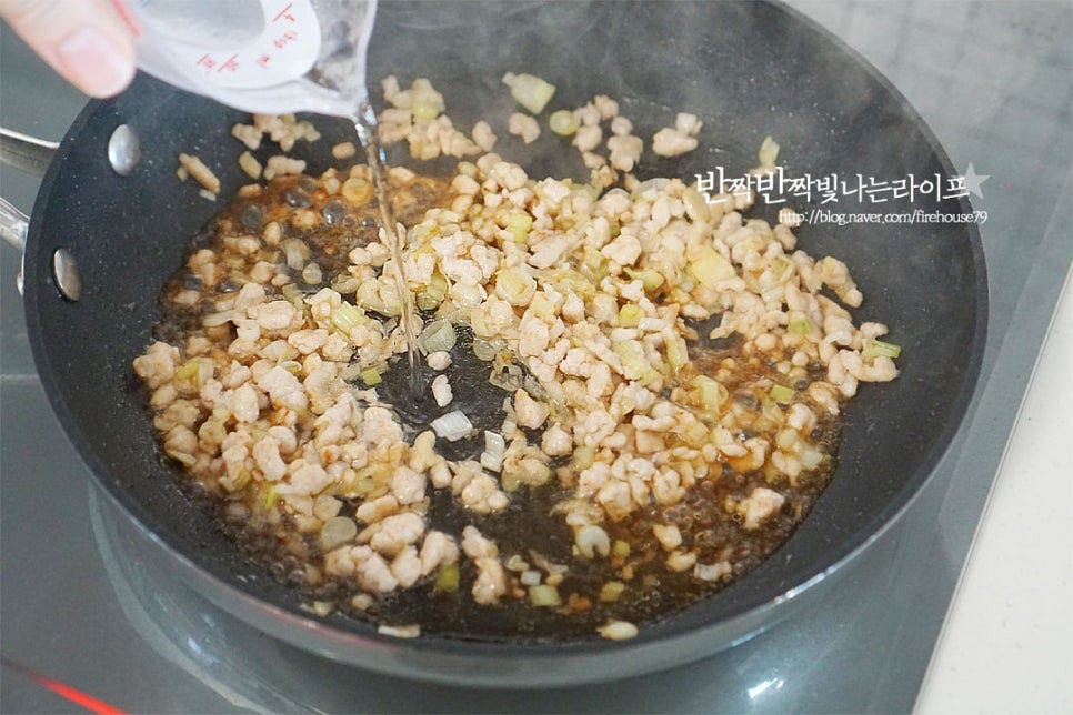 노릇하게 색이 나도록 볶다가 물 1/2컵을 부어줍니다. 물은 화력이나 양에 따라 조절해 주세요. 소스 1/2컵도 함께 넣어줍니다. 간에 따라 양념은 조절해주셔도 좋습니다. 된장 1 큰 술을 넣고 풀어줍니다. 된장은 염도에 따라 짜지 않게 넣어주고 된장이 들어가야 두반장의 맛이 납니다. 뭉치지 않게 잘 풀어 섞어줍니다.