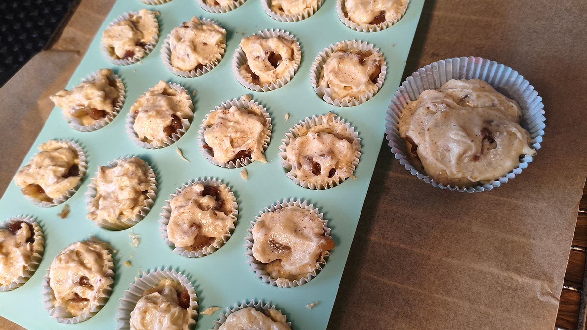 Ofen vorheizen: Umluft bei 160°C. Mini-Muffin-Blech mit Förmchen auslegen. Ca. die Hälfte des Teiges mit zwei keinen Teelöffeln in die Förmchen verteilen, eine Mulde einstreichen und die Apfelfüllung hinein geben. Mit dem restlichen Teig auffüllen, bis die Förmchen knapp gefüllt sind. Bei 160° C Umluft für 15 Minuten in den Backofen.