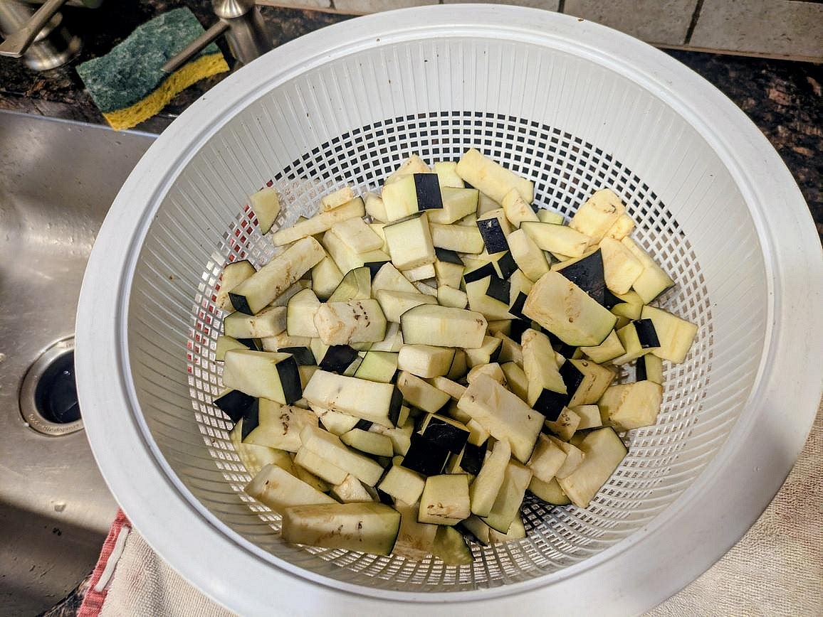 Wash your eggplant, and cut into a medium dice, leaving the skin on. Add the eggplant to a large strainer, and mix with salt. Let sit for at least 20 minutes for the salt to draw out the excess moisture from the eggplant
