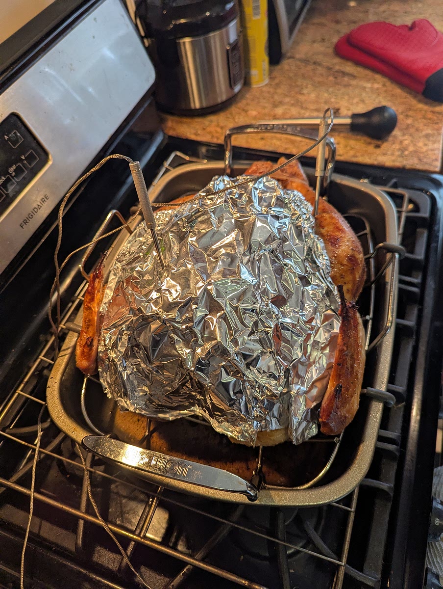 Phase 2 of roasting.
At this point when your skin is crisped to your liking, take the turkey out of the oven & reduce the temperature to 330.
You will then apply the breast plate back onto the turkey.
Also of note, the desired internal temperatures for the breast & thigh differ, with the breast goal being 157 for the breast & 175 for the thigh.
The breast plate helps slow the heating of the breast & allow for that temperature differential.
I also highly recommend using 2 thermo probes. One through the breast plate into the deepest part of the high breast, & one in the deepest part of the inner thigh. Being sure not to be contacting bone (these may need to be replaced as cooking goes on & you notice temperatures aren't moving the way you think they should. Often because of improper probe placement.)
Then place the bird back in the oven & allow to cook for 2-5 hours (depending on bird size), but the temperatures on the probes are what properly tell you when it is done.
Again. The breast should reach an internal temperature of 157, & the thigh should read 175. (Some choose to baste or coat the turkey during this time, but we find it unnecessary as it should have plenty of flavor & moisture as is & can make the skin too salty, or not crisp evenly.)