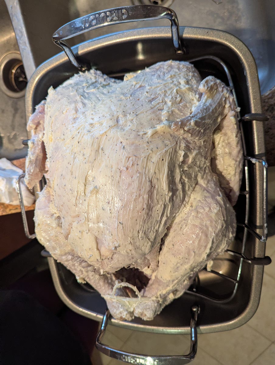 Buttering the turkey. (An optional, but highly recommended step)
At this point you should have your butter softened at room temperature. Mix the butter & seasonings together to make a soft compound butter.
You can then apply the butter to the entire bird. Starting under the skin & working the butter around until it is fairly evenly underneath, then coating the outside of the bird in what remains of the butter. After this you may stuff any aromatics back into the cavity & place the bird on a large turkey roasting pan to go into the oven.
(You may also choose to stuff the bird with another stuffing, though personally I find fully stuffing the bird makes it take longer to get the proper internal temp & causes the meat to often become overcooked).