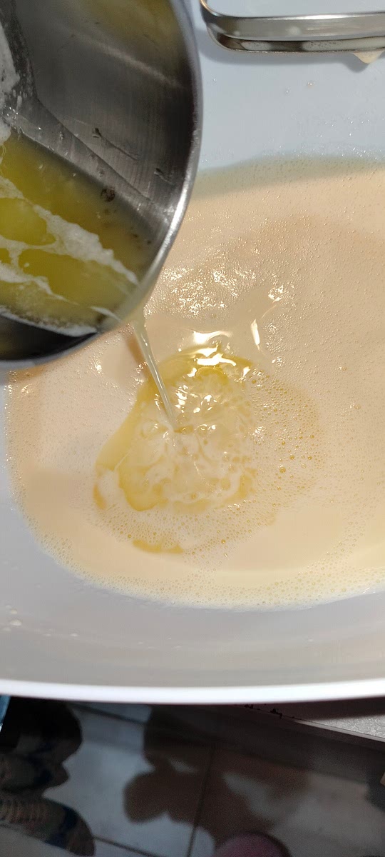 Aggiungi il burro fuso precedentemente intiepidito e mescolare aggiungendo poco alla volta la farina