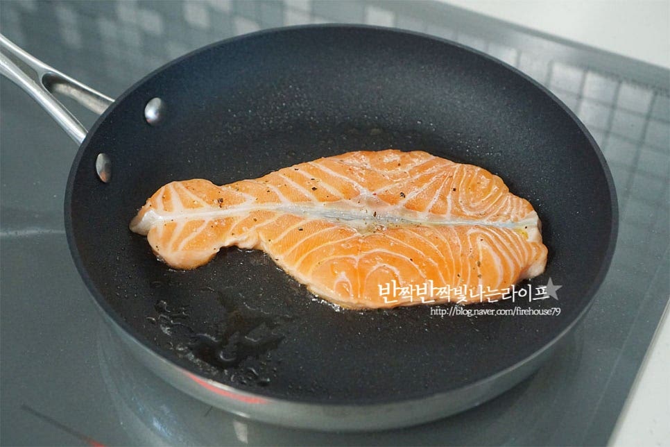 팬을 예열해 줍니다. 예열한 프라이팬에 연어를 올리고 구워줍니다. 따로 기름을 두르지 않고 구워도 재료에서 기름이 적당하게 나와 겉은 바삭 속은 촉촉하게 구워집니다. 겉만 타지 않도록 중간 센 불에서 한쪽 면이 노릇하게 구워지면 뒤집어 속까지 부드럽게 익을 수 있도록 해줍니다.