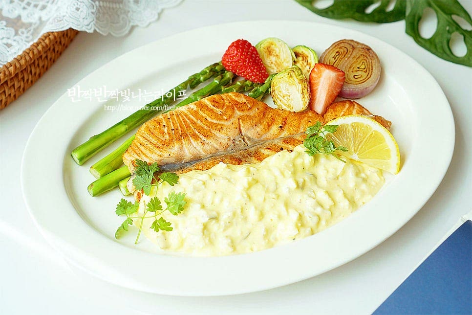 넓은 플레이트에 연어구이와 가니시, 타르타르소스를 끼얹어 완성합니다. 색감있게 멋스럽게 담아내면 집에서도 레스토랑 못지않게 맛볼 수 있어요. 영상도 같이 담았어요. 밑간하여 겉바속촉으로 구운 스테이크와 맛을 살려주는 소스까지 곁들인 레시피로 간단하게 맛볼 수 있습니다. 먹을수록 고소한 진한 풍미를 맛볼 수 있는 연어스테이크와 소스로 맛있는 요리를 즐겨보세요. 끄읕 !