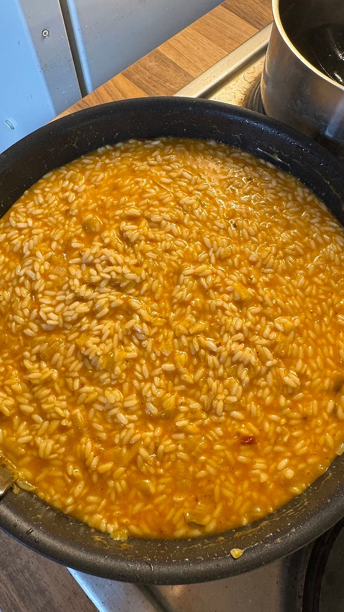 Cette étape concerne la cuisson du riz. Celui-ci doit frémir doucement (pas bouillir) tout au long de la cuisson. L’idée est de rajouter une louche de bouillon dès que la louche précédente a réduit. Comment savoir quand rajouter une louche ? Le riz doit être crémeux et se tenir, en le mélangeant on doit pouvoir voir le fond de la poêle pendant quelques secondes avant qu’il ne se referme.
Le riz ne doit jamais sécher.
Répéter l’ajout de louche jusqu’à ce que tout le bouillon y soit passé. Cette étape de cuisson peut durer jusqu’à 20 minutes.
Comment savoir que le riz est cuit ? Goûter, le riz doit être fondant mais il doit se tenir et ne pas faire une bouillie, il peut être légèrement plus dure vers le cœur pour une cuisson al dente.