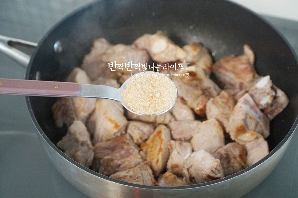 매콤한 양념을 한 번에 넣는 것이 아니라 조리 순서대로 넣어가며 고추기름을 내어 감칠맛을 더해줍니다. 구워진 돼지갈비에 설탕 5 큰 술을 넣어줍니다. 기본양념의 비율은 진간장 5 : 참치액 5 : 설탕 5인데요. 적당하게 단맛을 넣고 입에 감기는 맛을 내어주는데 조금 단맛이 있는 편이라 설탕량은 줄여 넣어도 좋을 것 같아요. 저는 4 큰 술 정도 넣었습니다. 설탕을 넣고 중불에서 윤기가 나도록 설탕 코팅을 해줍니다. 그리고 식초 1 큰 술을 넣어줍니다. 신맛은 요리하면서 날아가고 잡내를 잡기 위해 넣어주었습니다. 돼지고기를 냄비 한쪽으로 밀고 진간장 5 큰 술, 참치액 5 큰 술을 넣어줍니다. 바글바글 끓어오르면 전체적으로 골고루 섞어줍니다. 매운 마늘 갈비찜 맛으로 고춧가루 3 큰 술을 넣어줍니다. 아이가 먹을 것이라면 생략 가능해요. 빨갛게 어우러지면서 윤기가 나고 고추기름이 만들어져 때깔이 맛있어 보입니다. 양파와 대파, 간 마늘 3 큰 술을 넣어줍니다. 과일이 들어가지 않는 대신 양파와 대파는 조금 넉넉하게 넣어도 좋아요. 재료가 어우러지도록 볶으면 양념 통닭 색깔이 된답니다. 양념에서 중요한 팁은 바로 케첩인데요. 류수영 레시피는 토마토케첩을 넣고 깔끔한 고추 소스 맛을 더해줍니다. 케첩 2 큰 술을 넣어줍니다. 채소계의 조미료인 케첩이 들어가 고춧가루와 어우러지는 맛이 깊어져요. 양파가 숨이 죽을 때까지 눌어붙지 않게 계속 저어가며 볶아줍니다.