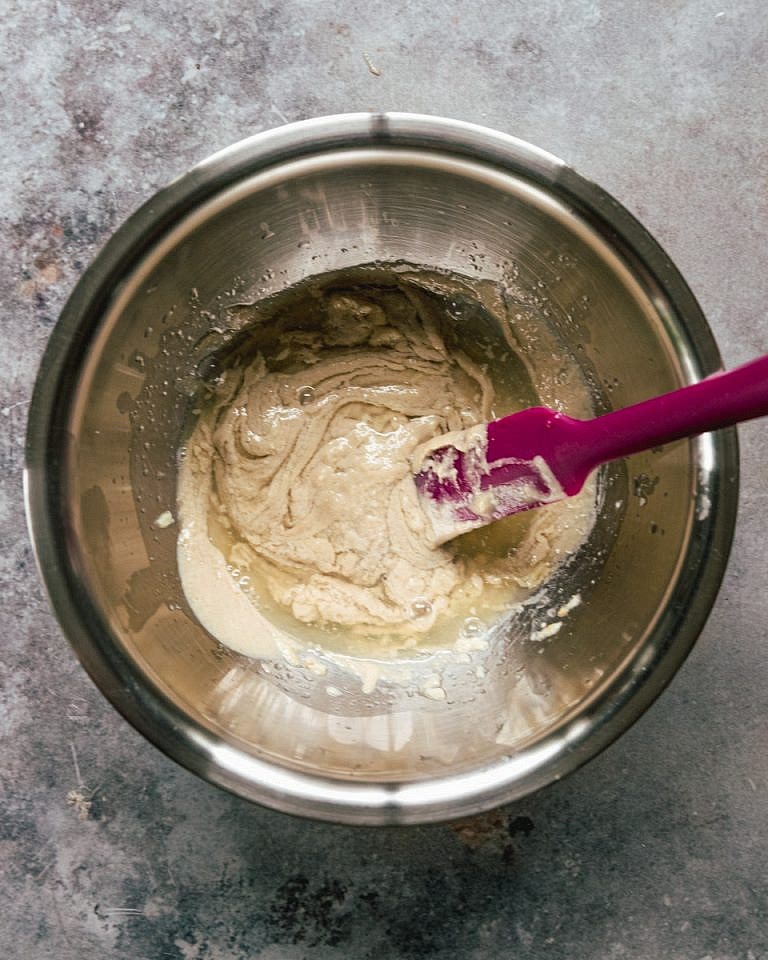 Start adding cold water, 1/4 cup at a time and mix well to combine. The paste will start changing color towards white. Repeat this step until the mixture become silky. Test it by grabbing a spoonfull and pore it back in. It should easily but slowly.
You want the thickness and texture to look like thick greek yogurt.