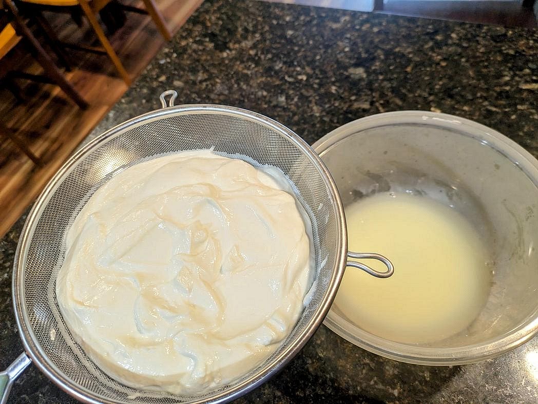 Place a fine mesh strainer over a medium bowl. Add the yogurt to the strainer, and mix in salt with a silicone spatula. Place the strainer over the bowl into the fridge, and allow it to drain (uncovered) for about 24 hours. I ended up with about 715 g of strained yogurt